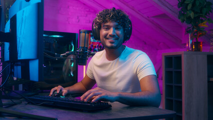 Indian Arabian Latina man talking shouting microphone influencer male excited guy gamer streamer radio host presenter emotional blogger vlogger online stream gaming playing video game addict in studio