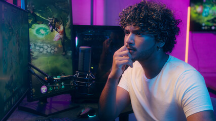 Thoughtful Arabian Indian man gamer playing video game cyber sport computer streamer male thinking strategy e-sport solution planning contemplate influencer vlogger ponder puzzled guy tournament home © Yuliia