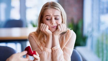 Bored millennial lady not willing to accept engagement ring, rejecting marriage proposal at cafe. Young woman saying NO to her boyfriend, refusing to marry with wrong candidate
