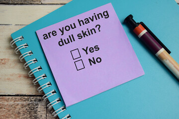 Are you having dull skin write on sticky notes isolated on Wooden Table. A person is answering question concept