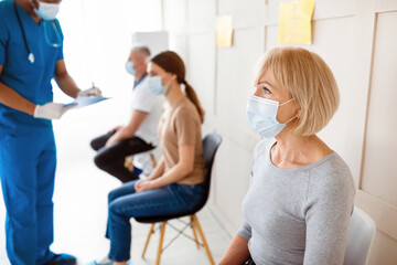 Obraz premium Senior woman waiting for covid-19 vaccine injection, doctor checking patients' health before immunization at clinic. Coronavirus vaccination, protection against viral diseases campaign