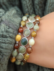 Stylish beaded bracelets stacked on a wrist with colorful gemstone beads.