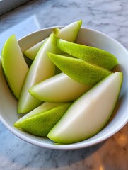 Sliced pears in bowl on marble top, serving on table, nutritious snacks, breakfast