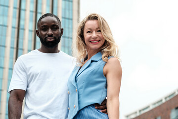 Happy interracial couple smiling together in urban setting