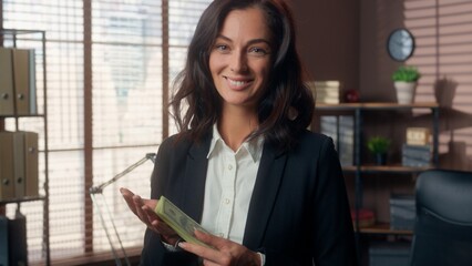 Happy Caucasian woman female girl wealth counting banknotes businesswoman bank dollars finance profit smelling stack of money sniff smell enjoy manager worker business office indoors rich earnings