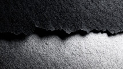 Abstract image showing a textured dark gray and light gray surface split.