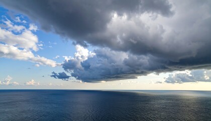 Obraz premium Dramatic storm clouds over the ocean Atmospheric seascape view with blue sky.