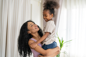 Obraz premium African mother and daughter hugging and love and strong family at home, african family lifestyle, smiling together emotional connection, family health insurance, motherhood and positive mental health