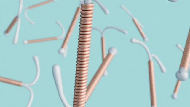 A 3D animation of scattered copper IUDs or Intrauterine Devices. The vertical stem of the 'T' is wrapped tightly with a coiled, copper-colored wire. The type of contraceptive.