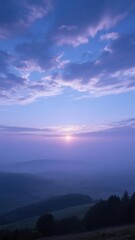 Obraz premium Dawn Over Rolling Hills with Misty Horizon