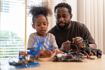 African father and daughter playing with stem robot kit, stem toys for kids fun learning and...