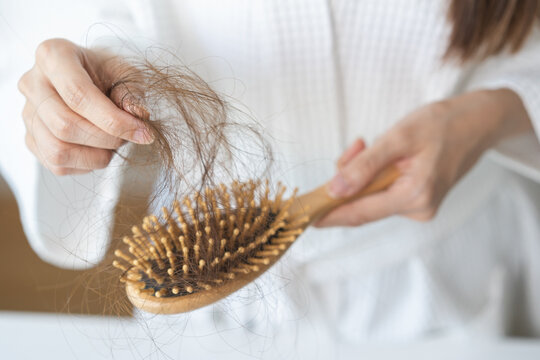 Stress asian young woman, girl hand holding comb show her hairbrush with loss, hair in brush after brushing, hair fall out problem. Health care, beauty with treatment concept, isolated on background.