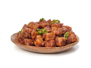 Oreg tempe or Indonesian food made from tempeh with soy sauce and spices on wooden plate isolated on white background