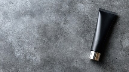 Fototapeta premium Elegant Black Cosmetic Tube on Stylish Gray Surface Background