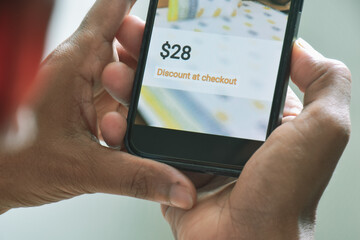 Mobile phone close-up displaying product price and discount at checkout. E-commerce marketing growth strategy tactics for reducing shopping cart abandonment concept.