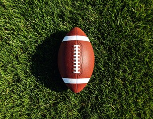 American football resting on vibrant green grass ready for competitive action