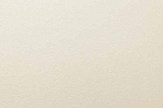 Close up view of ivory textured paper with subtle surface details