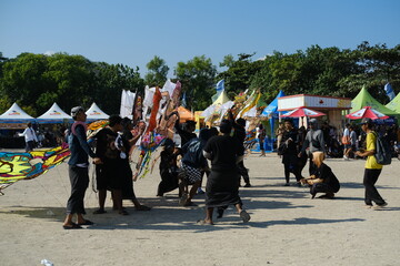 Group of boys carrying a large kite