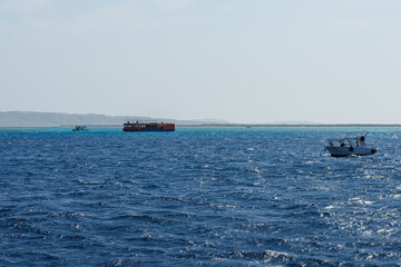 Boats on vibrant sea near island