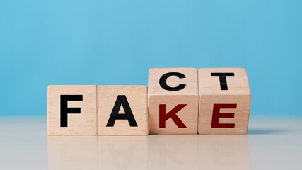 Wooden cube with flip over block FAKE to FACT. rumor News, false, myth, evidence and disinformation concepts