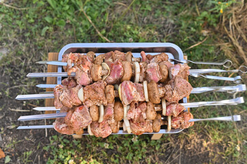  Raw meat pieces threaded onto metal barbecue skewer, glistening with marinade. uncooked beef or lamb shows fresh, deep red hues with visible marbling, ready for grilling over open flames.