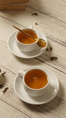 cup of tea, tea being poured into a transparent and white tea cup, teapot and tea cup with floral motif, darmkmood tea photo display
