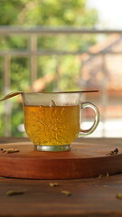 cup of tea, tea being poured into a transparent and white tea cup, teapot and tea cup with floral motif, darmkmood tea photo display