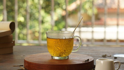 cup of tea, tea being poured into a transparent and white tea cup, teapot and tea cup with floral motif, darmkmood tea photo display