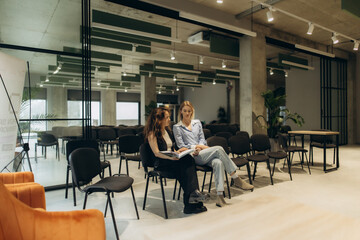 Fototapeta premium Two Women Collaborating in a Modern Stylish Conference Room with Large Windows