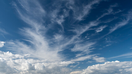 cotton-like clouds that were drawn in stripes by the wind across the blue sky