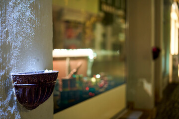 Ornament on a facade. Illuminated trough on a building in front of reflection in the window.