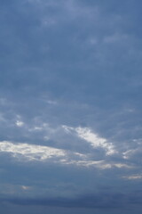 Bedeckter leichter blauer schöner Himmel am Abend mit etwas Sonne, die hindurch scheinen kann