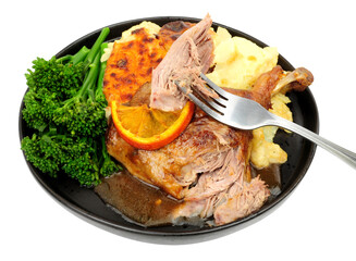 Roast duck leg with creamy dauphinoise potatoes, broccoli and orange sauce meal isolated on a white background