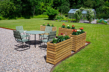 Old outdoor furniture and newely built high flower beds