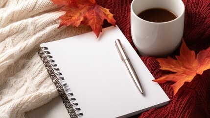 Cozy autumn scene featuring a blank notebook, pen, and coffee cup surrounded by colorful leaves