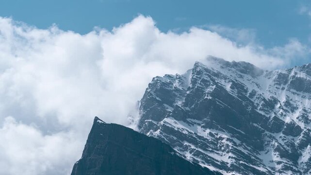 4K Zoom In time lapse shot of dark monsoon clouds covering the snowy glacier on a mountain peak during the monsoon season as seen from Khangsar village in Lahaul Valley, Himachal Pradesh, India.