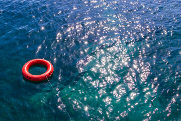 Orange lifebuoy floating on the surface of the ocean, needed help for those who fall overboard. 
