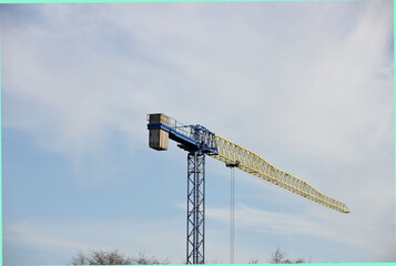 Tower cranes work during the construction of a multi-story building. New apartments for residents and premises for offices. Risky work at height. Lifting heavy building materials. City development