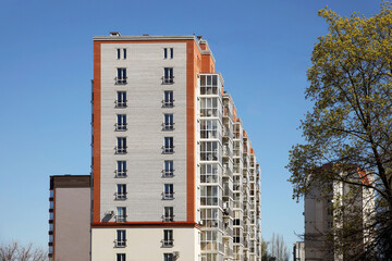 Lviv, Ukraine - 3 4 2020: Facade of a tall multi-storey modern house with balconies and large glass windows. Design of modern architecture. Top view from the bottom. Modern city architecture