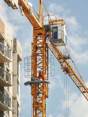 Tower cranes work during the construction of a multi-story building. New apartments for residents and premises for offices. Risky work at height. Lifting heavy building materials. City development