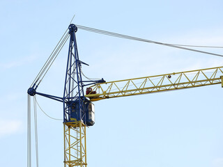 Tower cranes work during the construction of a multi-story building. New apartments for residents and premises for offices. Risky work at height. Lifting heavy building materials. City development