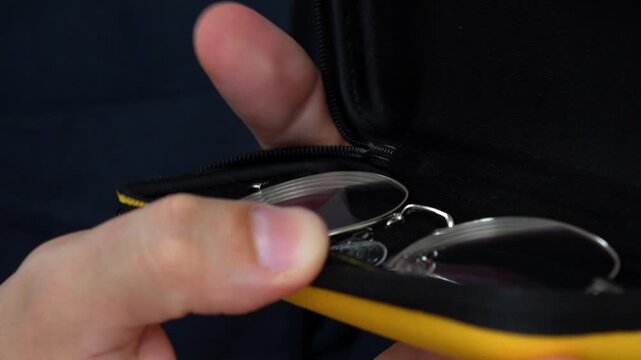 A person puts glasses in a case for storage.
Storing glasses for vision in a special shockproof case so as not to damage them.
Protecting glasses from falls and impacts