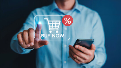 Man's hand presses digital buy now button with shopping cart and discount, phone in other hand
