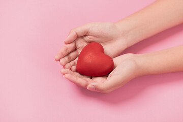 woman hands giving a red heart, red heart in young girl hands , health care, organ donation, family life insurance, world heart day, brain stroke. love concept.