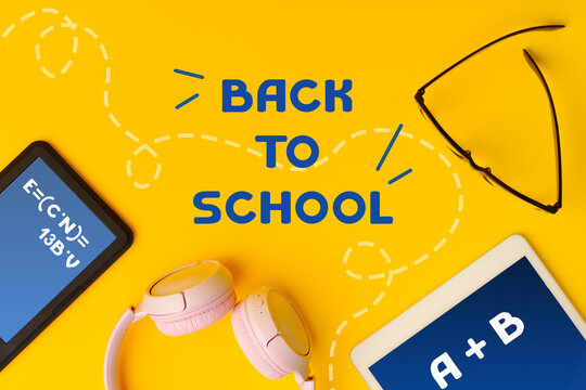 Bright back to school setup with school supplies, gadgets, and accessories on vibrant yellow background - Powered by Adobe