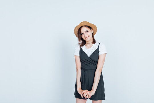 brunette woman in sherts and straw hat on white background