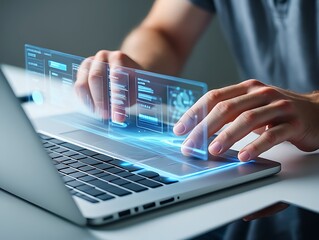 Hands typing on a laptop with a futuristic holographic interface displaying data and charts
