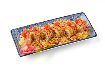 Crispy sushi roll topped with tempura flakes, spicy mayo, and fish roe served on decorative rectangular plate with pickled ginger and leaf garnish, creating vibrant and appetizing presentation