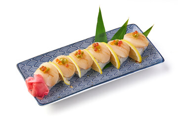 Delicious scallop sushi served on decorative plate with lemon slices, garnished with roe and pickled ginger, creating visually appealing and appetizing presentation