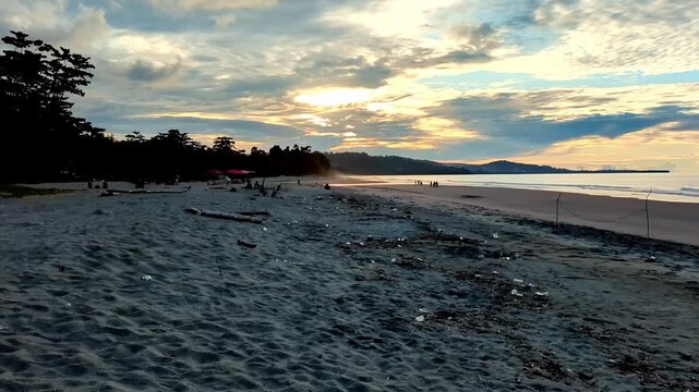 Evening timelapse at Amban Beach, Manokwari, West Papua, Indonesia, with calm waves and golden sunset sky.